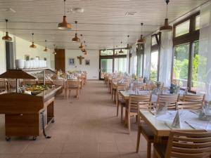 a dining room with tables and chairs and windows at Schönstattzentrum Aulendorf in Aulendorf