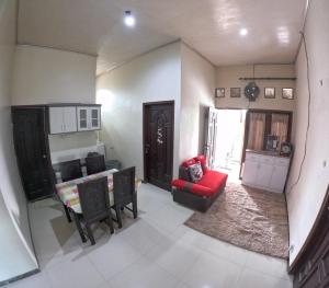 a living room with a red couch and a table at Omah Wirokerten Syariah Homestay Jogja in Gondowulung