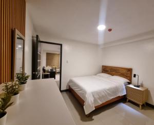 a white bedroom with a bed and a mirror at Flat 35, Unit 2A in Manila