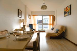 a living room with a table and a couch at Studio proche plage quartier Arago Les Sables d'Olonne - 4 personnes in Les Sables-dʼOlonne