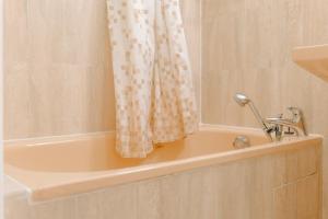 a bath tub with a shower curtain in a bathroom at Studio proche plage quartier Arago Les Sables d'Olonne - 4 personnes in Les Sables-dʼOlonne