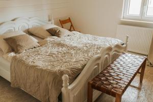 a bedroom with a white bed and a bench at Familienhof Waida in Dennheritz