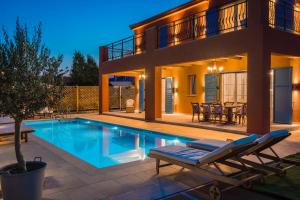 a villa with a swimming pool and a house at Villa Annino in Karavados Village with private Pool! in Karavadhos