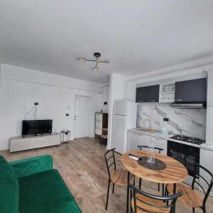 a living room with a table and a kitchen at Vily Apartment in Focşani