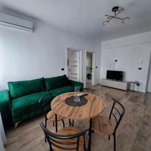 a living room with a green couch and a table at Vily Apartment in Focşani