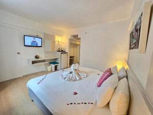 a bedroom with a large white bed with pillows at ON Hotel Phuket - SHA in Karon Beach