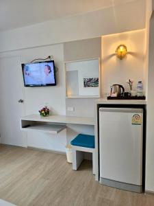 a room with a counter and a tv on the wall at ON Hotel Phuket - SHA in Karon Beach