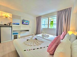 a bedroom with a large bed with two swans on it at ON Hotel Phuket - SHA in Karon Beach +176 photos