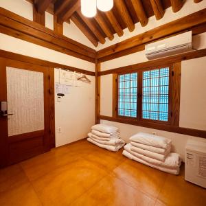 a room with a pile of towels and a fan at Jeonju Hanok village Deoksugung in Jeonju