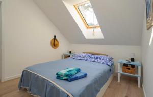 Un dormitorio con una cama con sábanas azules y una ventana. en Nice Apartment In Dziwnów With Wifi, en Dziwna