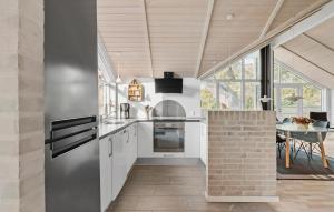 a kitchen with white cabinets and a brick wall at 3 Bedroom Amazing Home In Sydals in Skovmose