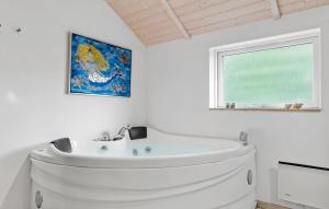 a white bathroom with a white tub and a window at 3 Bedroom Amazing Home In Sydals in Skovmose