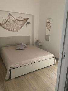Le Dimore del Mare في توري كان: غرفة نوم مع سرير مع أرجوحة معلقة على الحائط