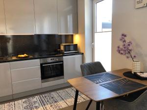 a kitchen with a table and a stove and a microwave at V71A Kauno Centre in Kaunas