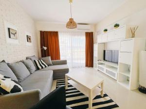 a living room with a couch and a table at Spacious & Modern 1 Bedroom Holiday Home in Perivolia tou Trikomou