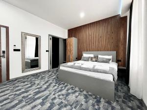 a bedroom with a large bed and a mirror at Residence Inn Orijent in Sarajevo