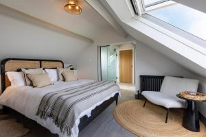 a bedroom with a bed and a window and a chair at Sandfield House in Whitby