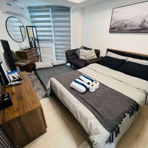 a bedroom with a bed with two towels on it at Azure North Pampanga Bachelor Pad in San Fernando