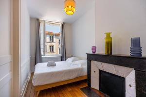een kleine slaapkamer met een bed en een open haard bij Le Cœur des Dominicains - pour 6 centre de Nancy in Nancy