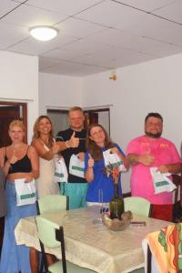 een groep mensen die rond een tafel staan bij Villa Green Garden in Hikkaduwa
