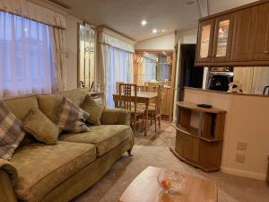a living room with a couch and a table at Severnside Boat and Caravan Park Gloucestershire - Caravan 1 in Deerhurst