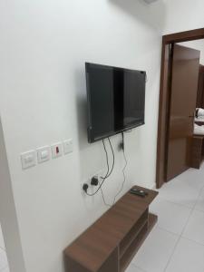 a flat screen tv hanging on a wall at Evora إيفورا in Sharurah