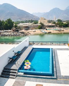 a swimming pool next to a body of water at 3BR villa and maid room by escape time in Sharm +17 photos