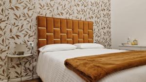 a bedroom with a large bed with a brown blanket at La Maison del Duomo in Catania