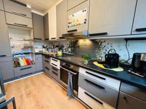 a kitchen with white cabinets and a black counter top at Appartments - Stromberg & Zabergäu in Erligheim