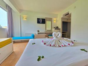 a large white bed with a wedding dress on it at ON Hotel Phuket - SHA in Karon Beach
