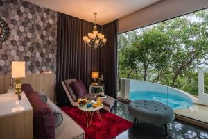a living room with a glass table and a swimming pool at Cocohut Beach Resort Koh Phangan in Haad Rin
