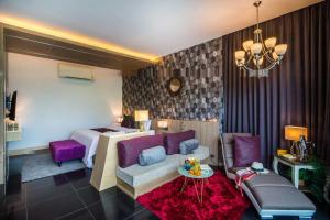 a hotel room with a bed and a couch and a table at Cocohut Beach Resort Koh Phangan in Haad Rin