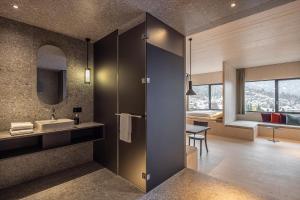 um banheiro com uma pia e um espelho em Me and All Hotel Flims, by Hyatt em Flims