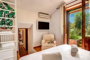 マッサ・ルブレンセにあるVilla Sorrentina With Panoramic Terraceのベッドと椅子と窓のある寝室