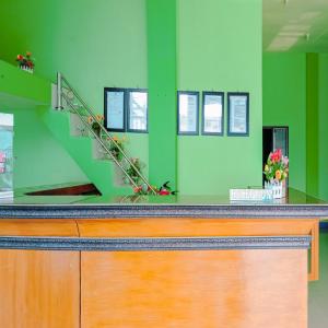 Una habitación verde con un mostrador con una escalera. en Hotel Pabelan RedPartner, en Bengkulu
