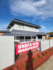 a sign on a fence in front of a house at Parkway Motel in Queanbeyan