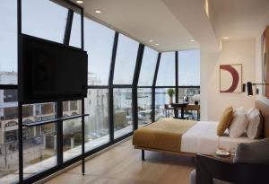 a bedroom with a bed and a flat screen tv at Noa Hotel in Thessaloniki