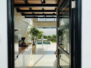 a glass door leading into a kitchen with a patio at Canggu 2Plex Apartment in Canggu