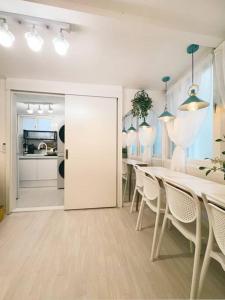 een witte eetkamer met een tafel en stoelen bij Inwangsan Stay in Seoul