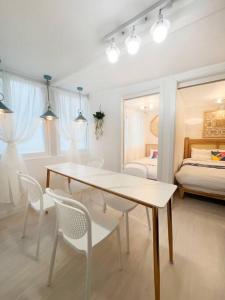 een witte kamer met een tafel en stoelen en een bed bij Inwangsan Stay in Seoul