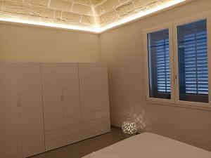 a room with white cabinets and a window at La Casa del Moro in Favignana