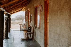 a porch of a house with a chair and a window at Harmony Game Lodge in Middlerus