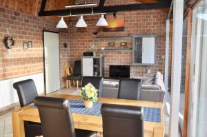 a dining room with a table and a brick wall at Boerenslag 17 in Sint Maartenszee