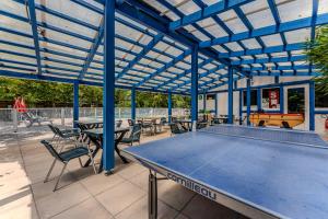 a ping pong table in a pavilion with tables and chairs at Mobil Home Confort Avec Clim 6 in Onesse-et-Laharie