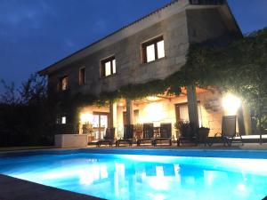 dom z basenem nocą w obiekcie Casa da Lomba Piscina y vistas al mar en Baiona w mieście Baiona