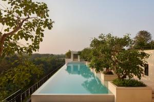 a swimming pool with trees on the side of a building at Hotel Tentrem Jakarta in Serpong