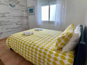 una camera da letto con un letto giallo e bianco con cuscini di Villa Cristipaulo a Praia de Faro Altre 32 foto