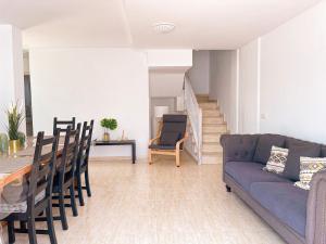 a living room with a couch and a table and chairs at Vivilanza Surfhouse in Costa Teguise