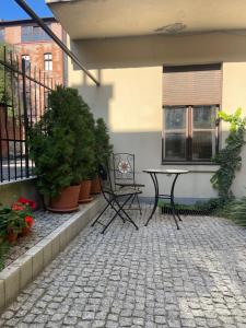 a patio with a table and chairs and plants at Piernikarska 4 łazienki in Toruń