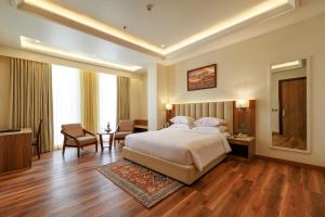 a hotel room with a bed and a desk and chair at Regenta Place Jaipur , Jaipur in Jaipur